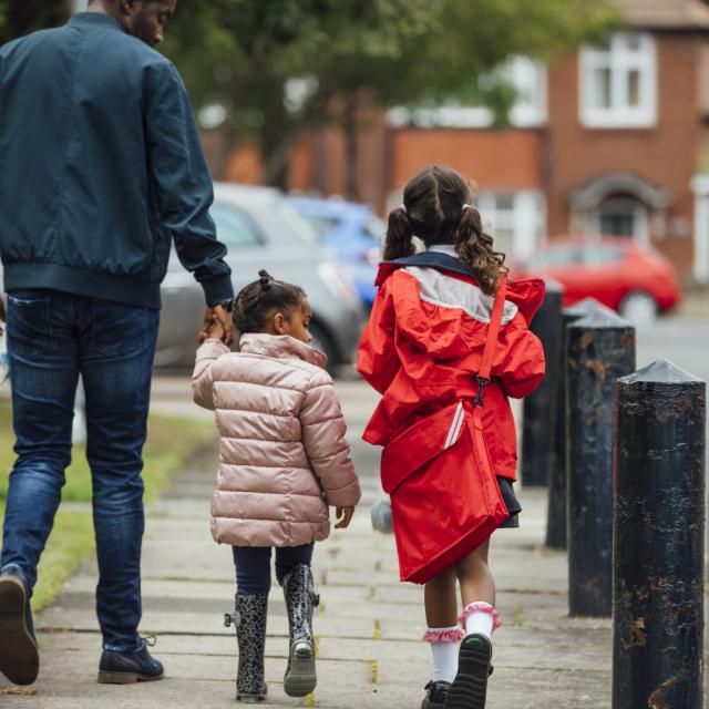 Children walking to school alongside a guardian