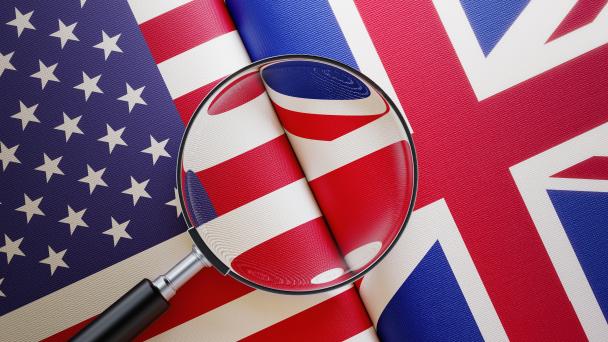 US and UK flags under a magnifying glass