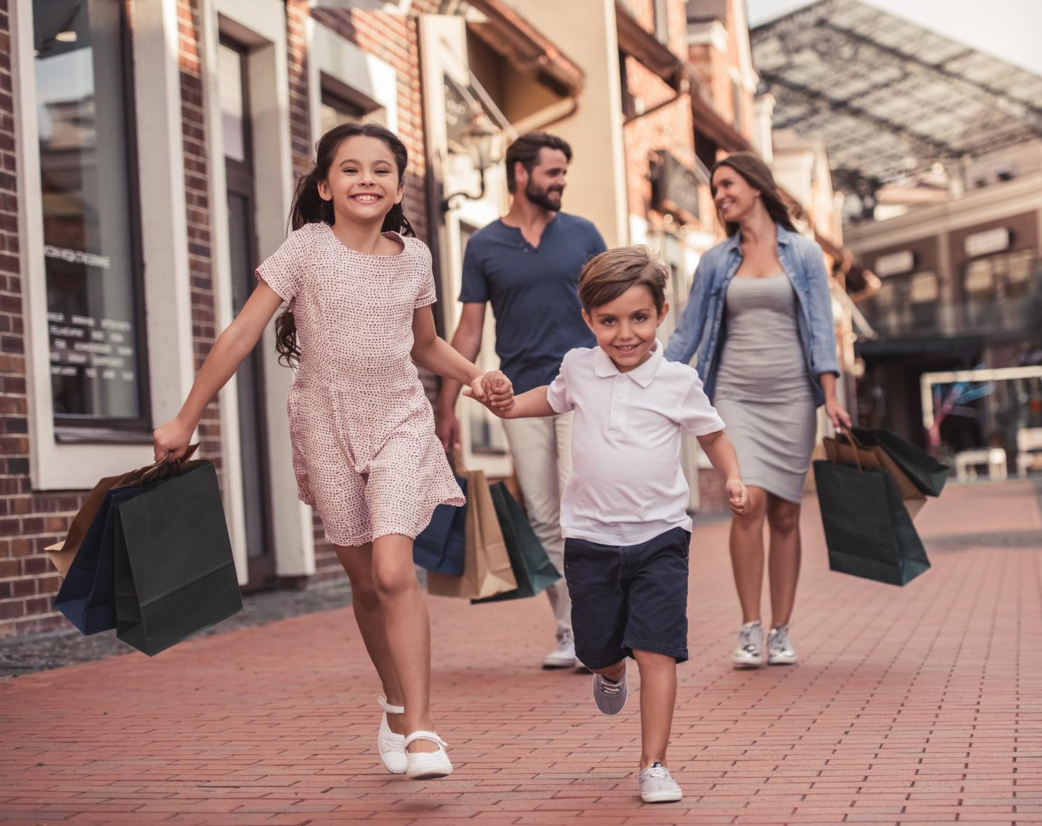 Children running ahead with parents walking behind